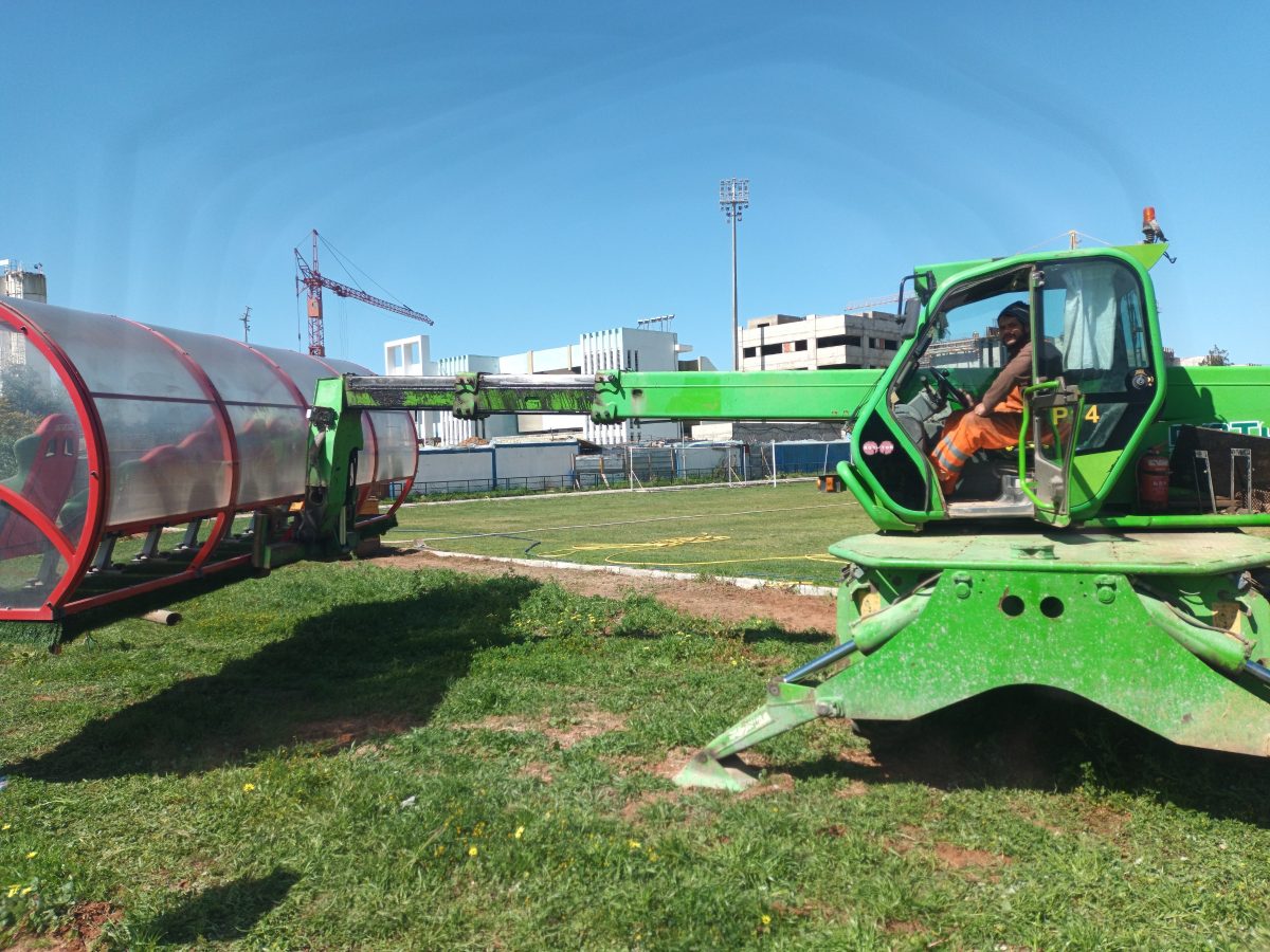 Chariot télescopique vert manœuvrant sur un terrain