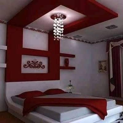 Chambre à faux plafond rouge et blanc et lit sur estrade