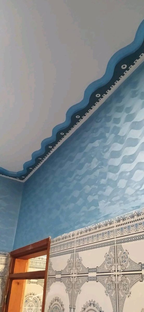 Mur bleu texturé à frise ondulée et zellige