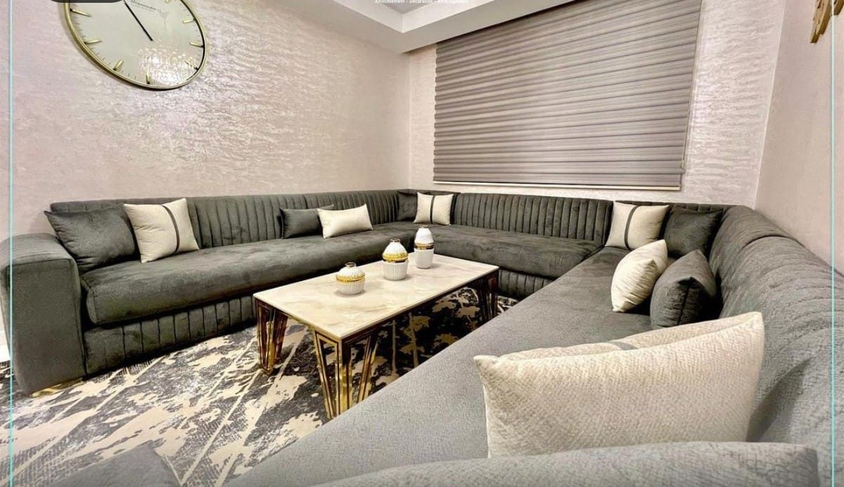 Grand salon en U en velours gris à coussins clairs