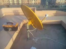 Antenne parabolique jaune installée sur une terrasse