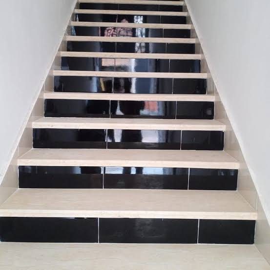 Escalier carrelé à contremarches noires et marches beige