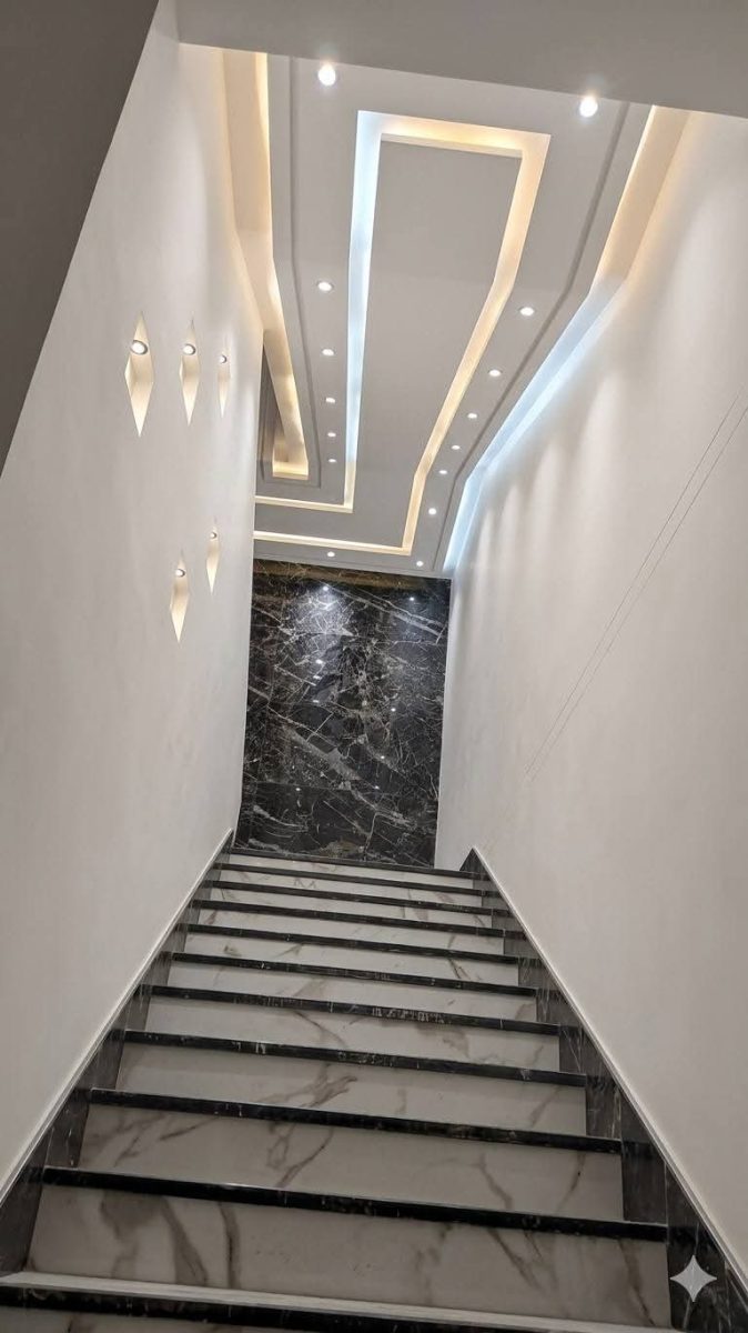 Cage d'escalier à faux plafond étagé et appliques