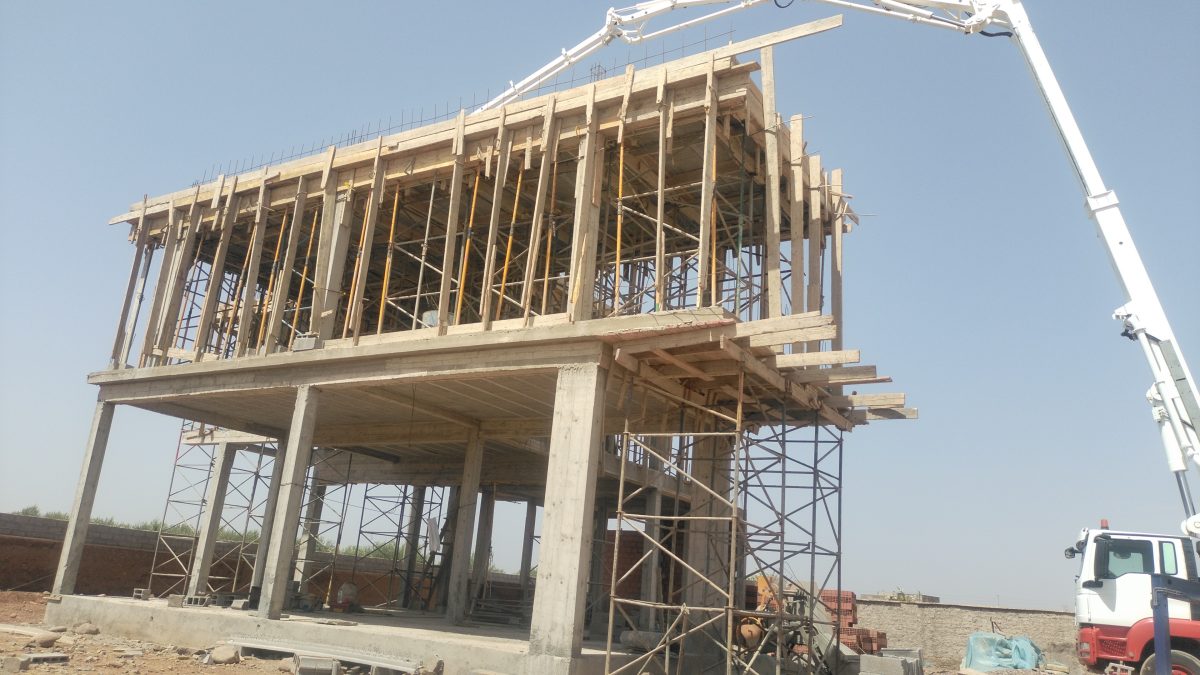 Bâtiment en construction à coffrage bois et pompe à béton