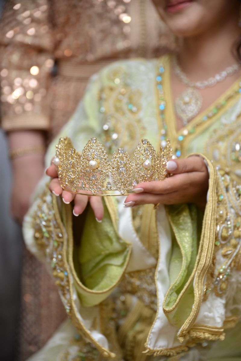 Mariée en caftan vert et or présentant un diadème