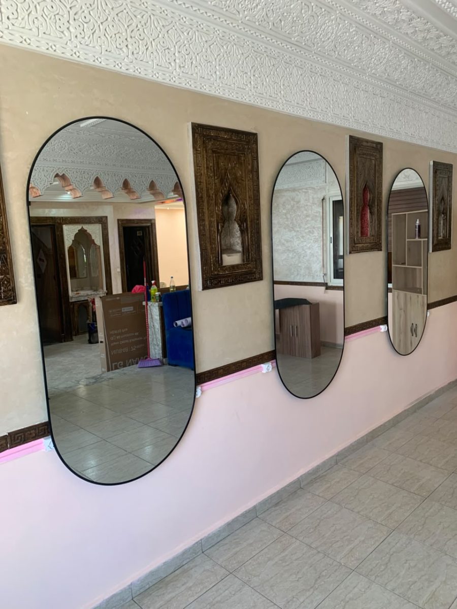 Miroirs ovales à cadre noir le long d'un couloir