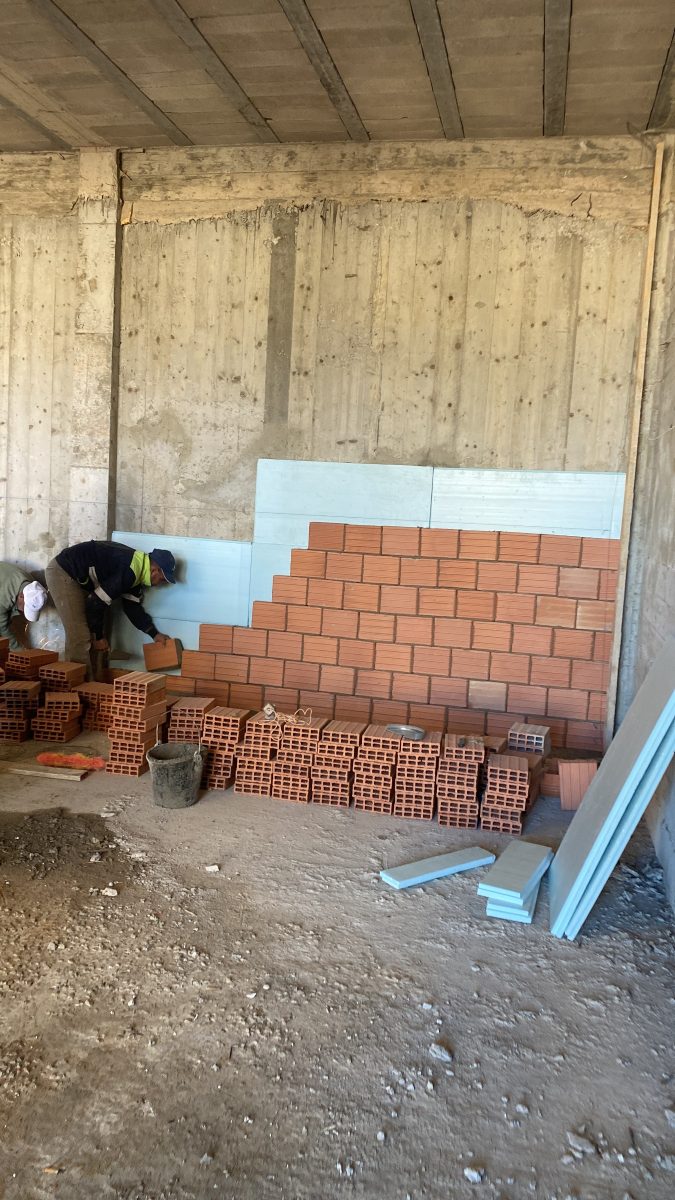Montage d'un mur en briques doublé de panneaux isolants