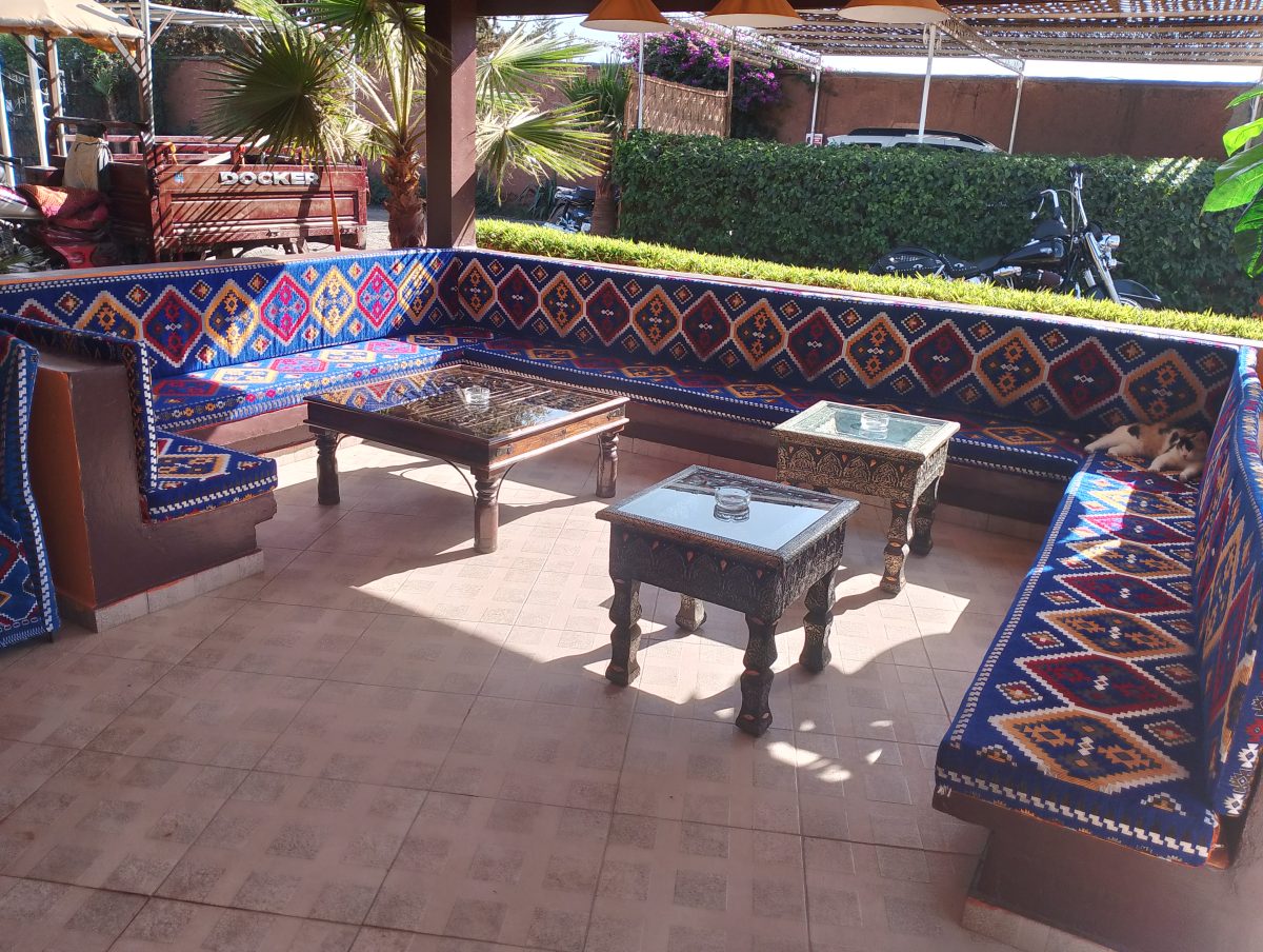 Salon d'extérieur à motifs berbères sous une pergola