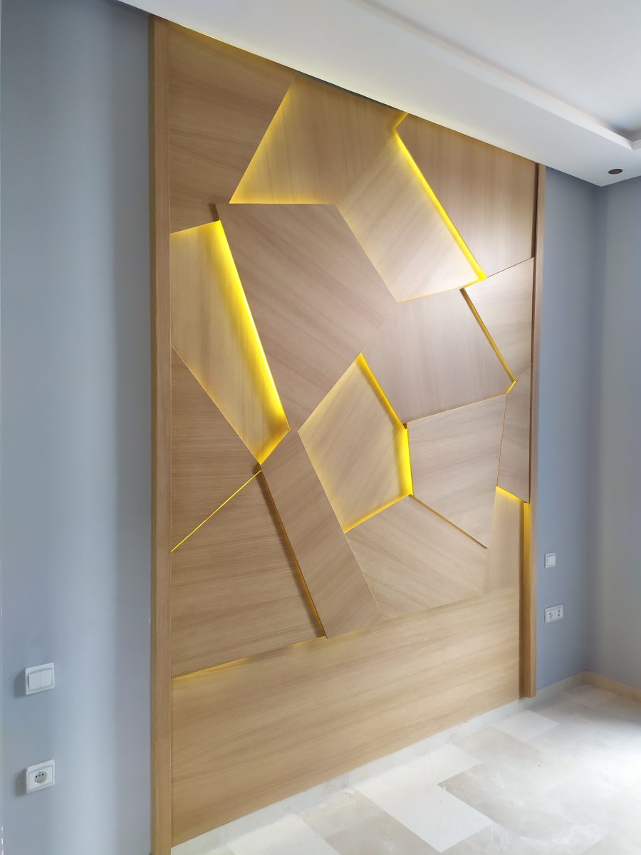 Habillage mural en bois à facettes et LED dorée
