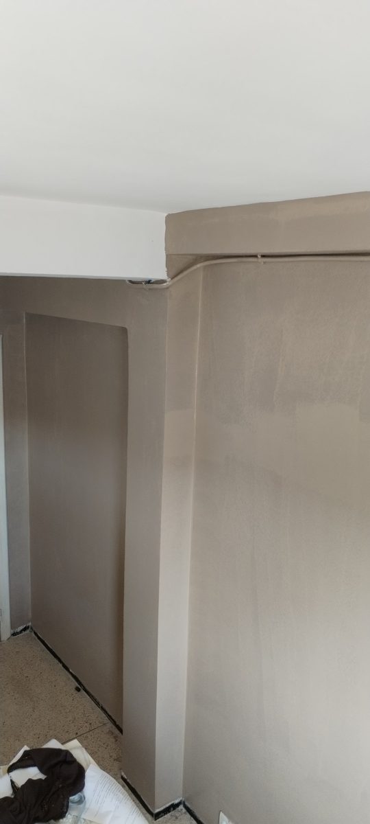 Mur en enduit décoratif taupe à effet béton ciré