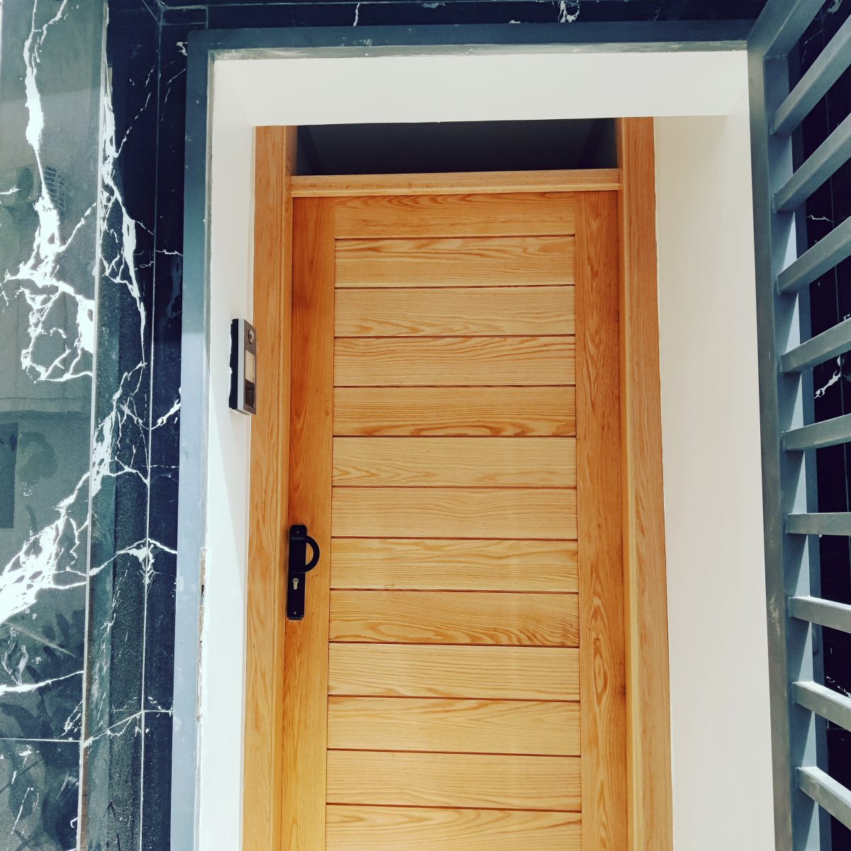 Porte d'entrée en bois clair à lames horizontales