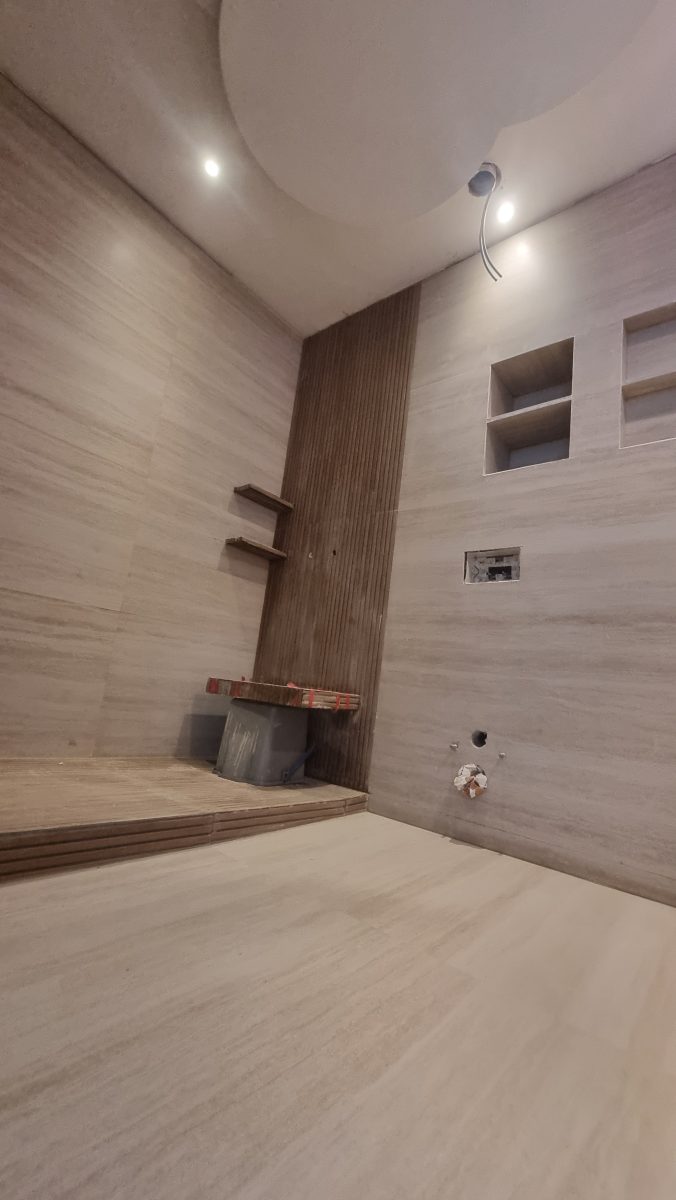 Salle de bain effet travertin à banquette et tasseaux
