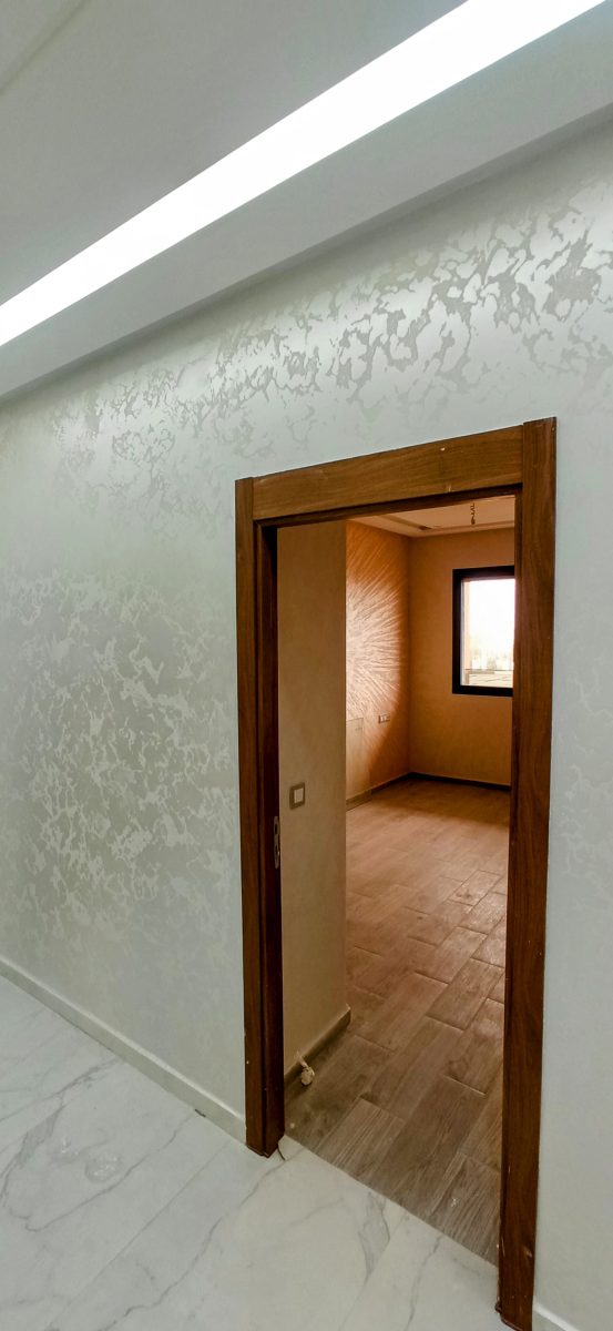 Mur en enduit décoratif gris nacré à porte bois