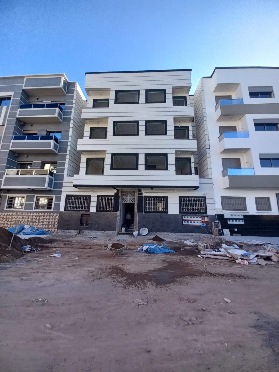 Façade d'immeuble à crépi bicolore blanc et gris