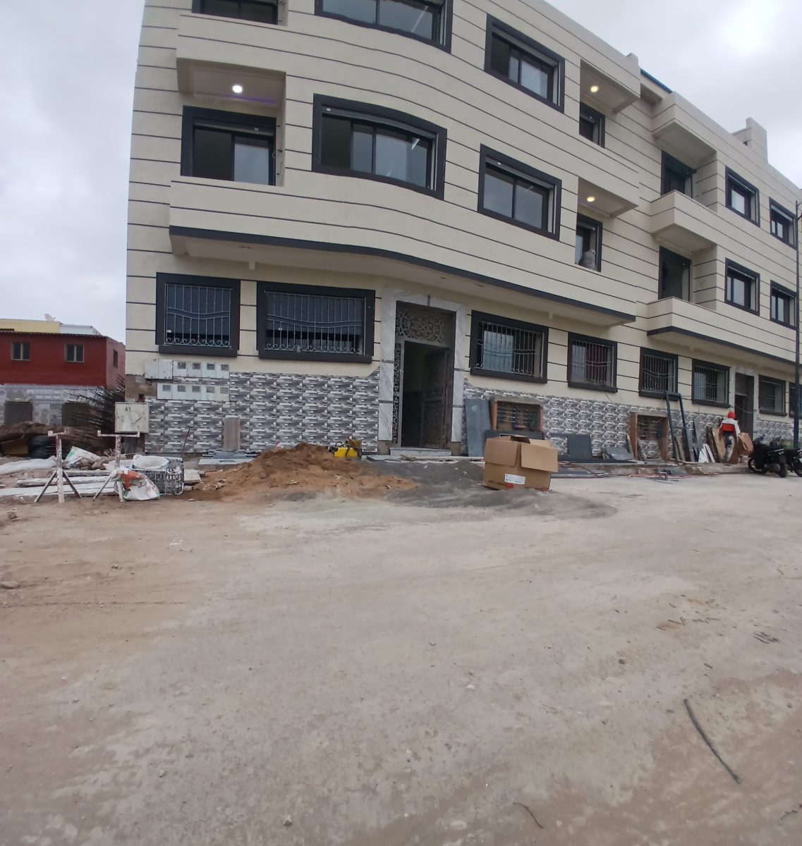 Façade d'immeuble enduite beige en chantier