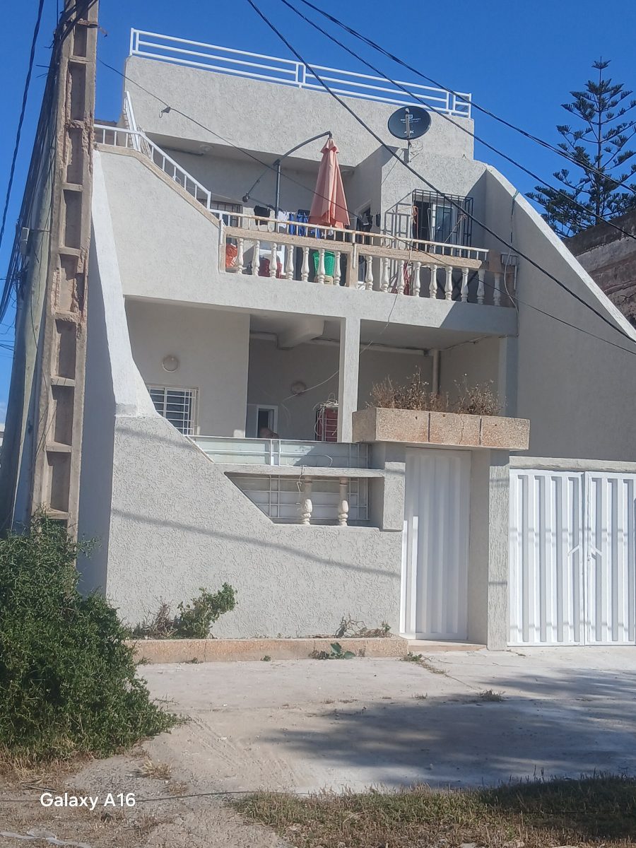 Façade de maison à crépi gris et balcon