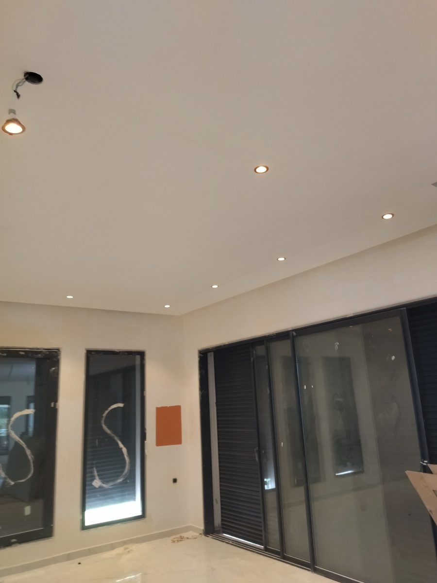 Pièce à faux plafond à spots et baies vitrées noires