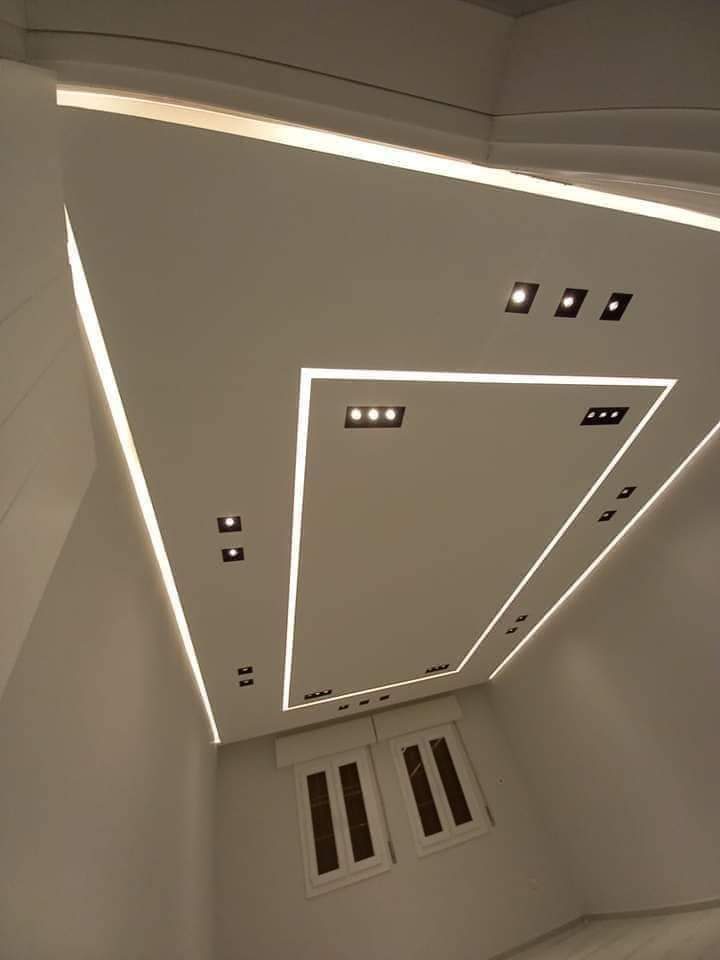 Faux plafond à cadre lumineux trapézoïdal et spots