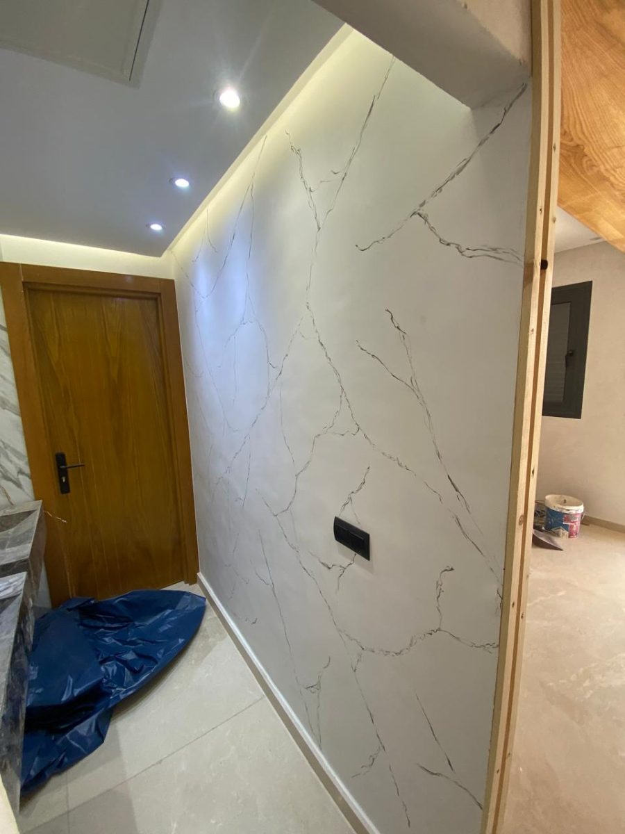 Couloir à pan effet marbre blanc et faux plafond éclairé