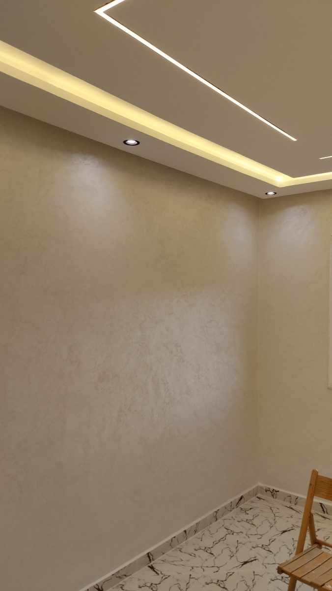 Pièce en enduit crème nacré sous faux plafond éclairé