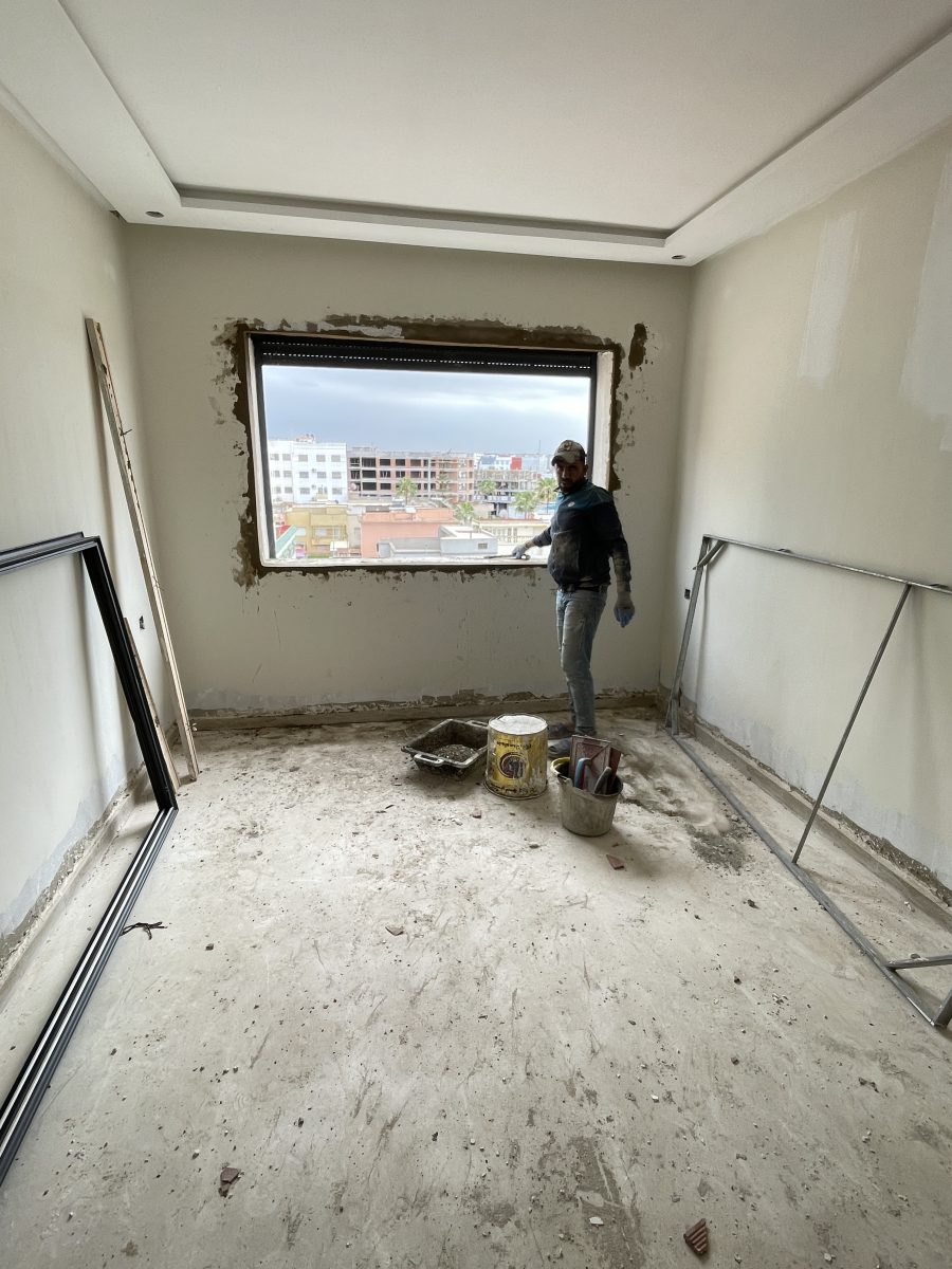 Application d'enduit autour d'une fenêtre en travaux