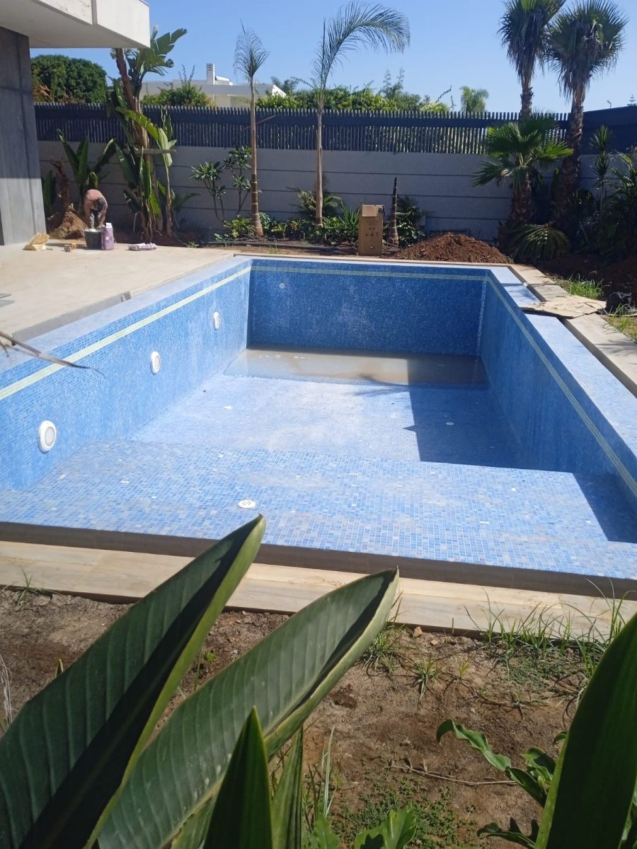 Piscine à revêtement en mosaïque bleue en jardin