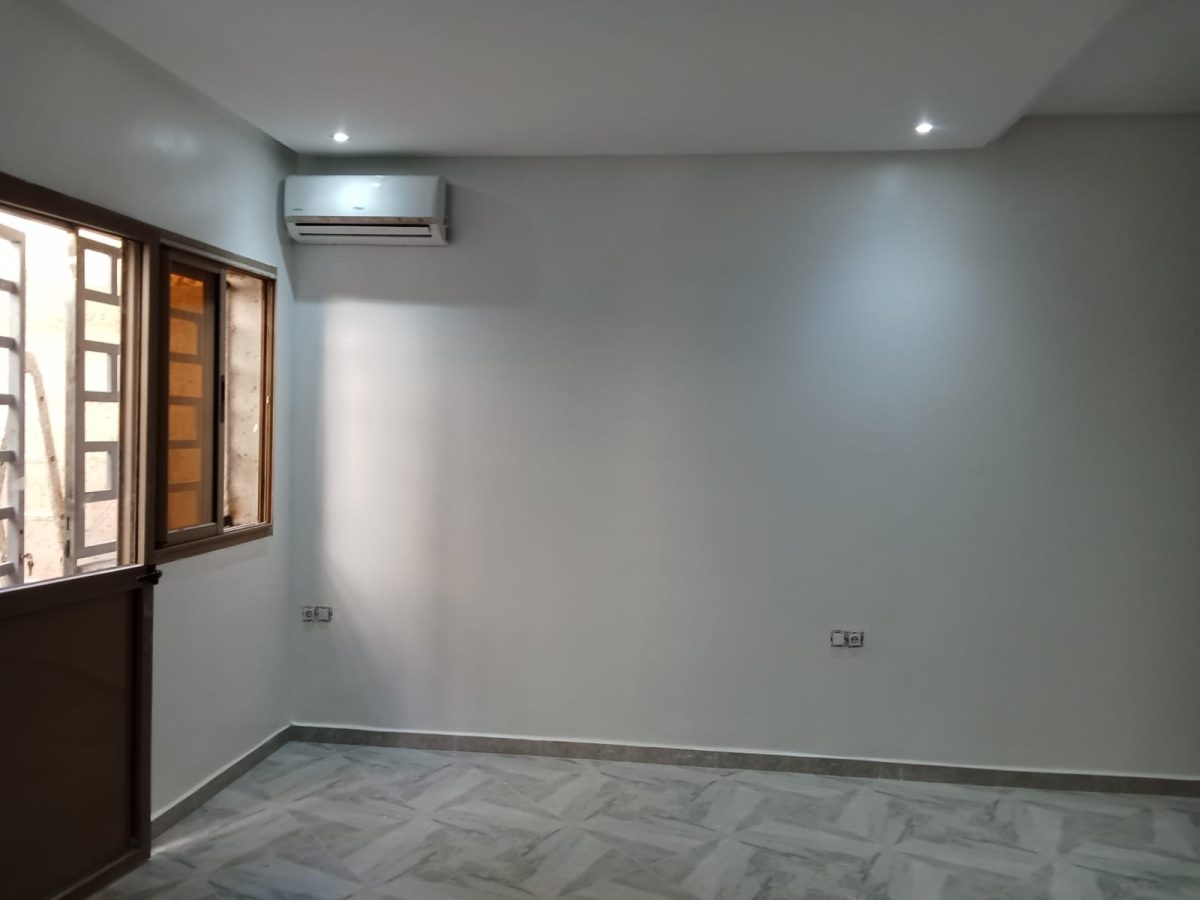Chambre peinte en blanc et gris à fenêtre en bois