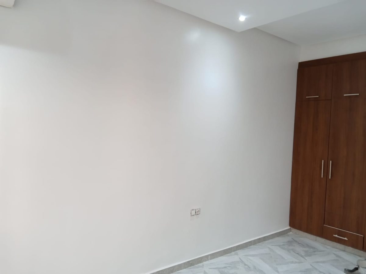 Chambre peinte en blanc avec armoire en bois