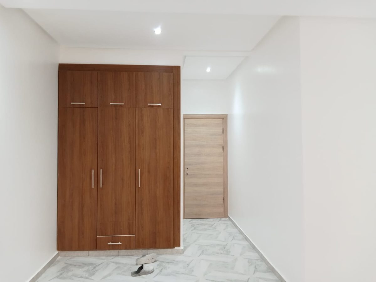 Chambre peinte en blanc à armoire en bois trois portes