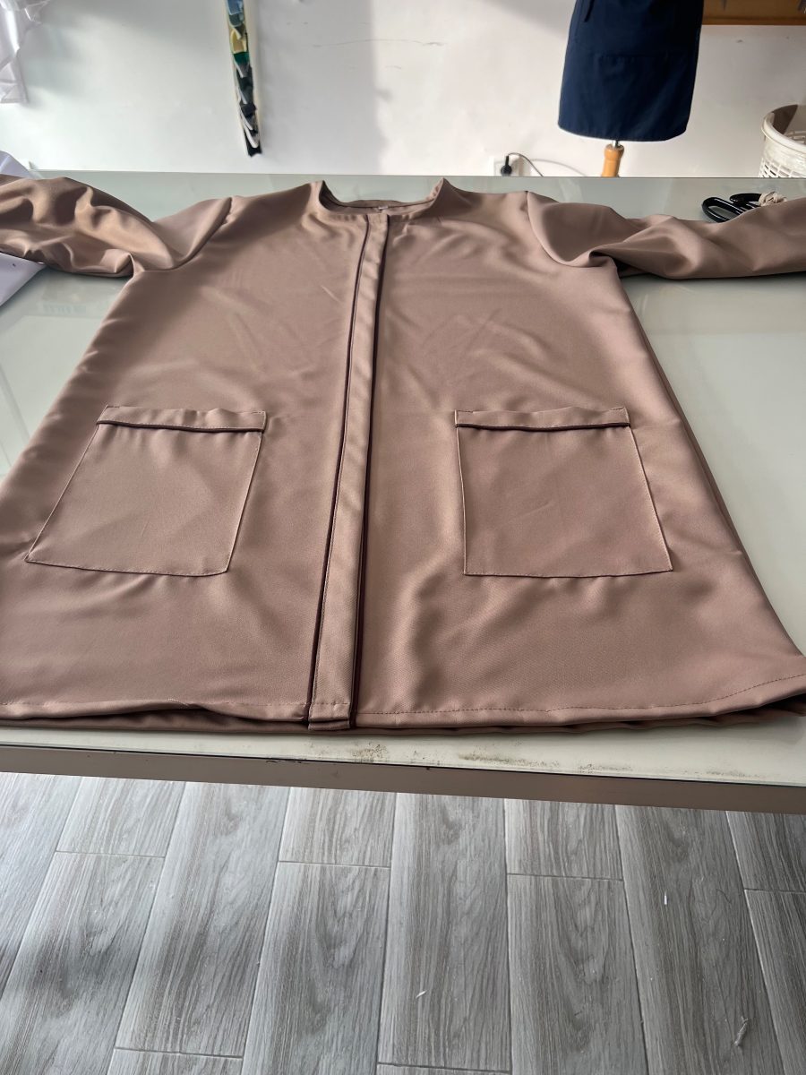 Blouse de travail taupe sur une table de coupe
