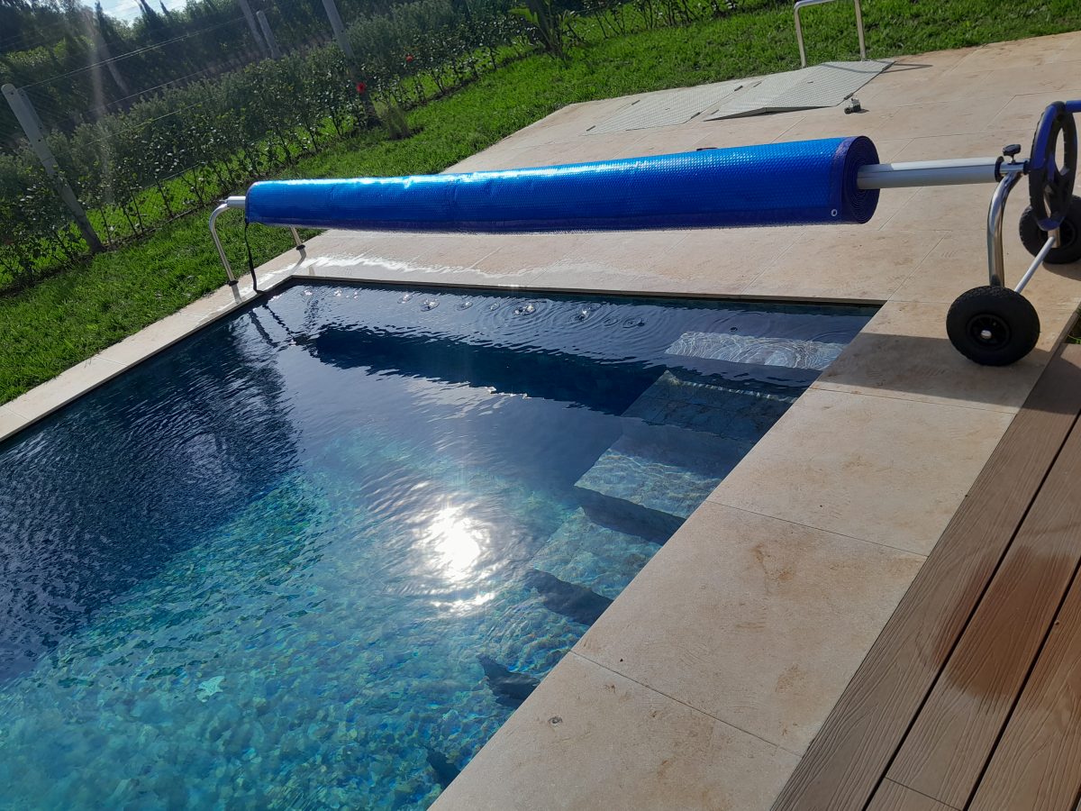 Piscine à débordement à enrouleur de bâche