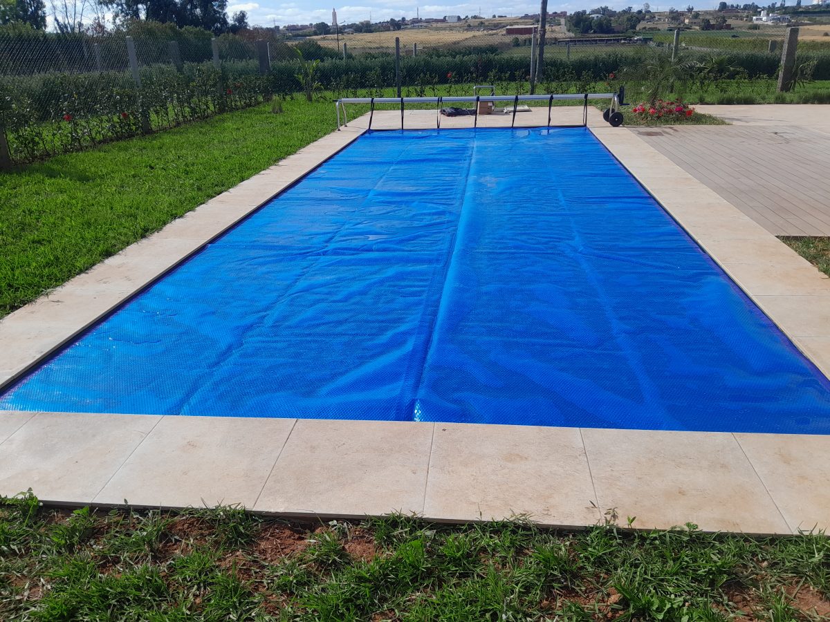 Piscine couverte d'une bâche à bulles bleue