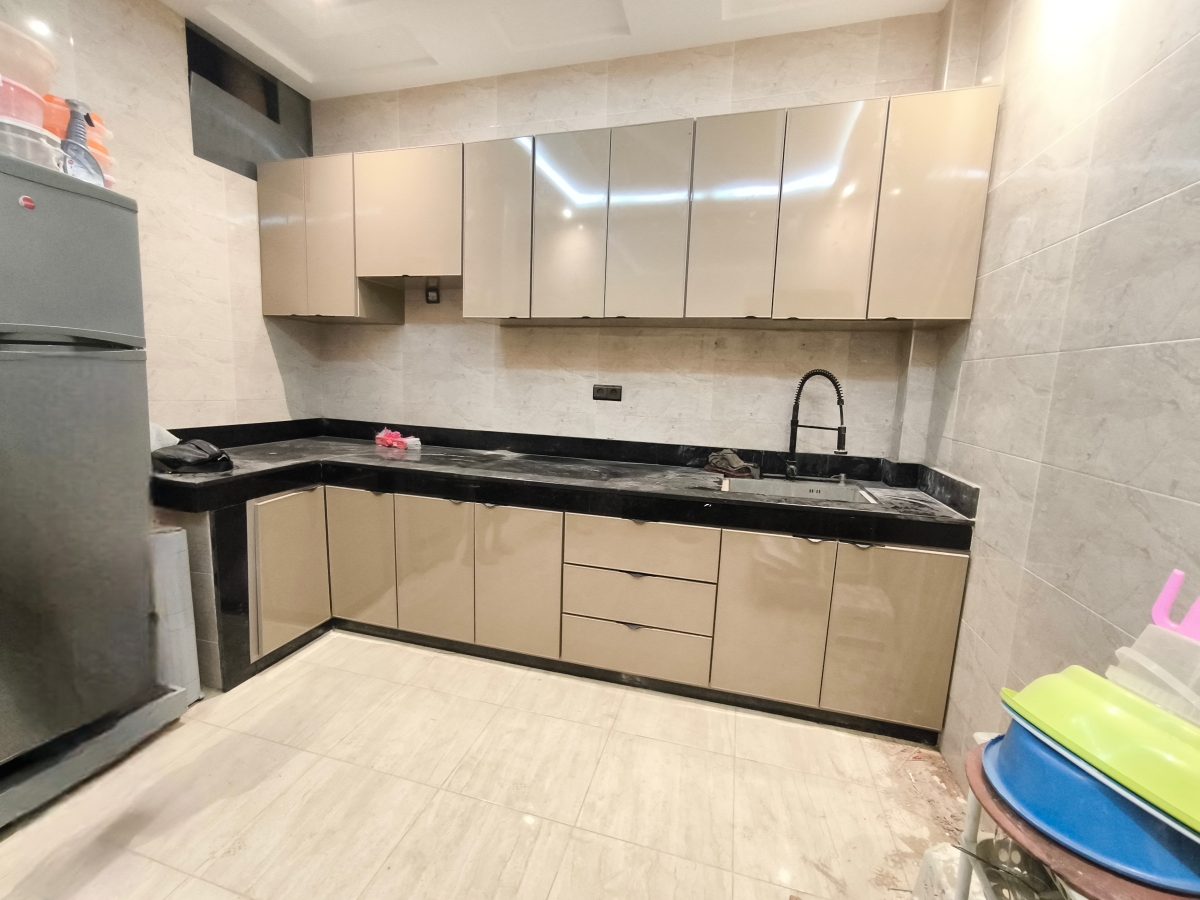 Cuisine en L taupe laquée à plan en granit noir
