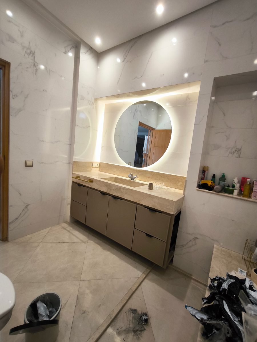 Salle de bain en marbre à miroir rond rétroéclairé