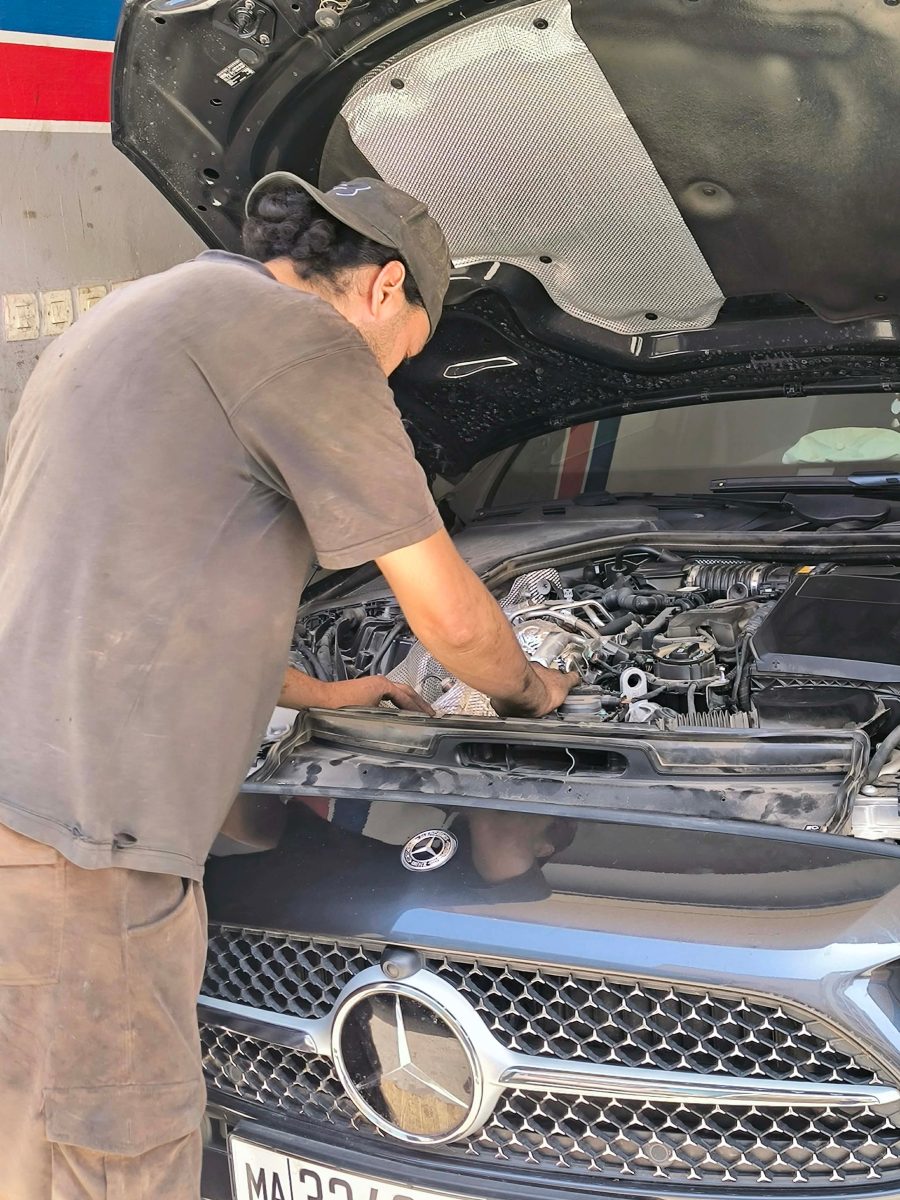 Mécanicien intervenant sur un moteur de berline