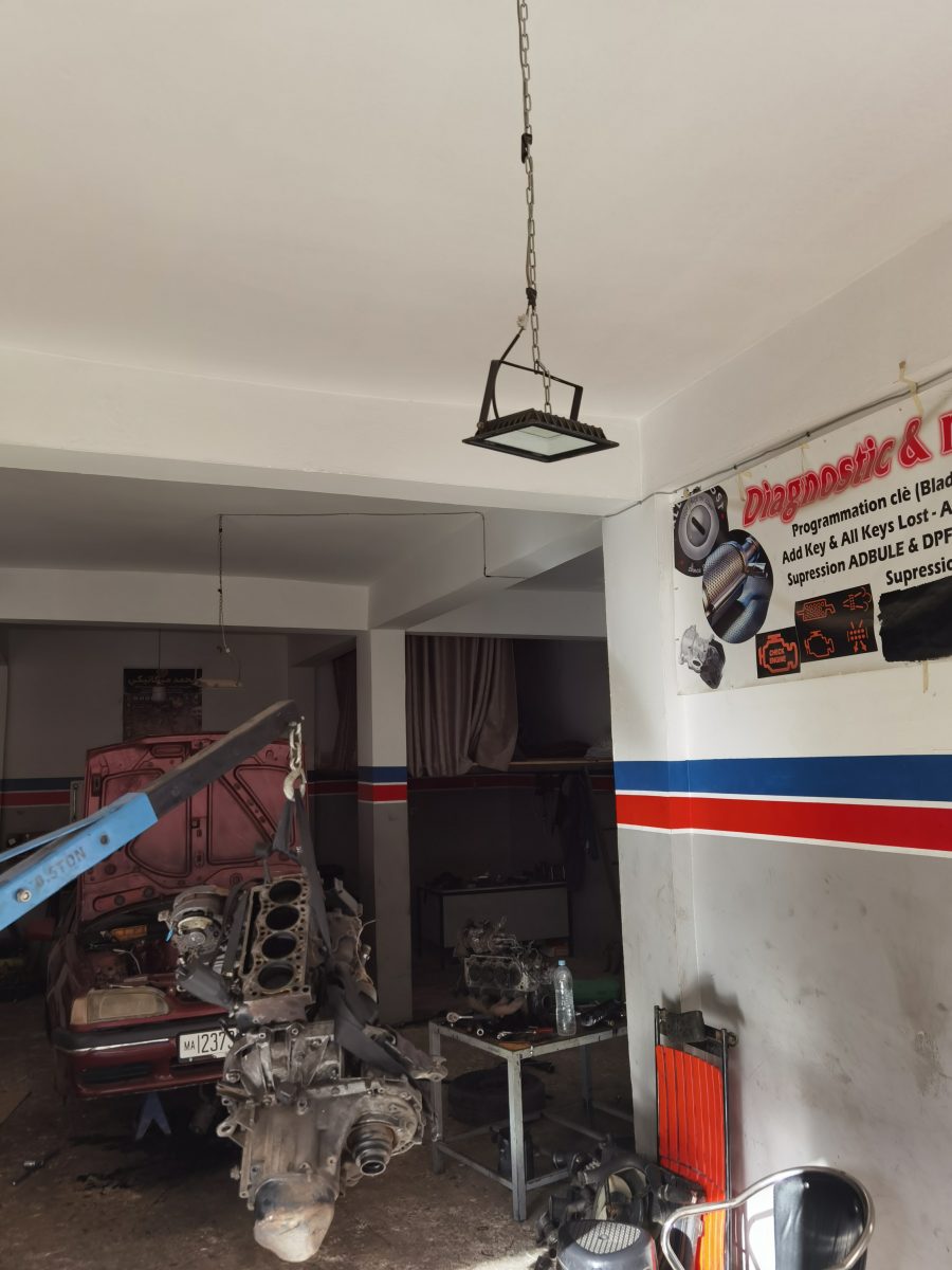 Bloc moteur démonté sur palan dans un garage