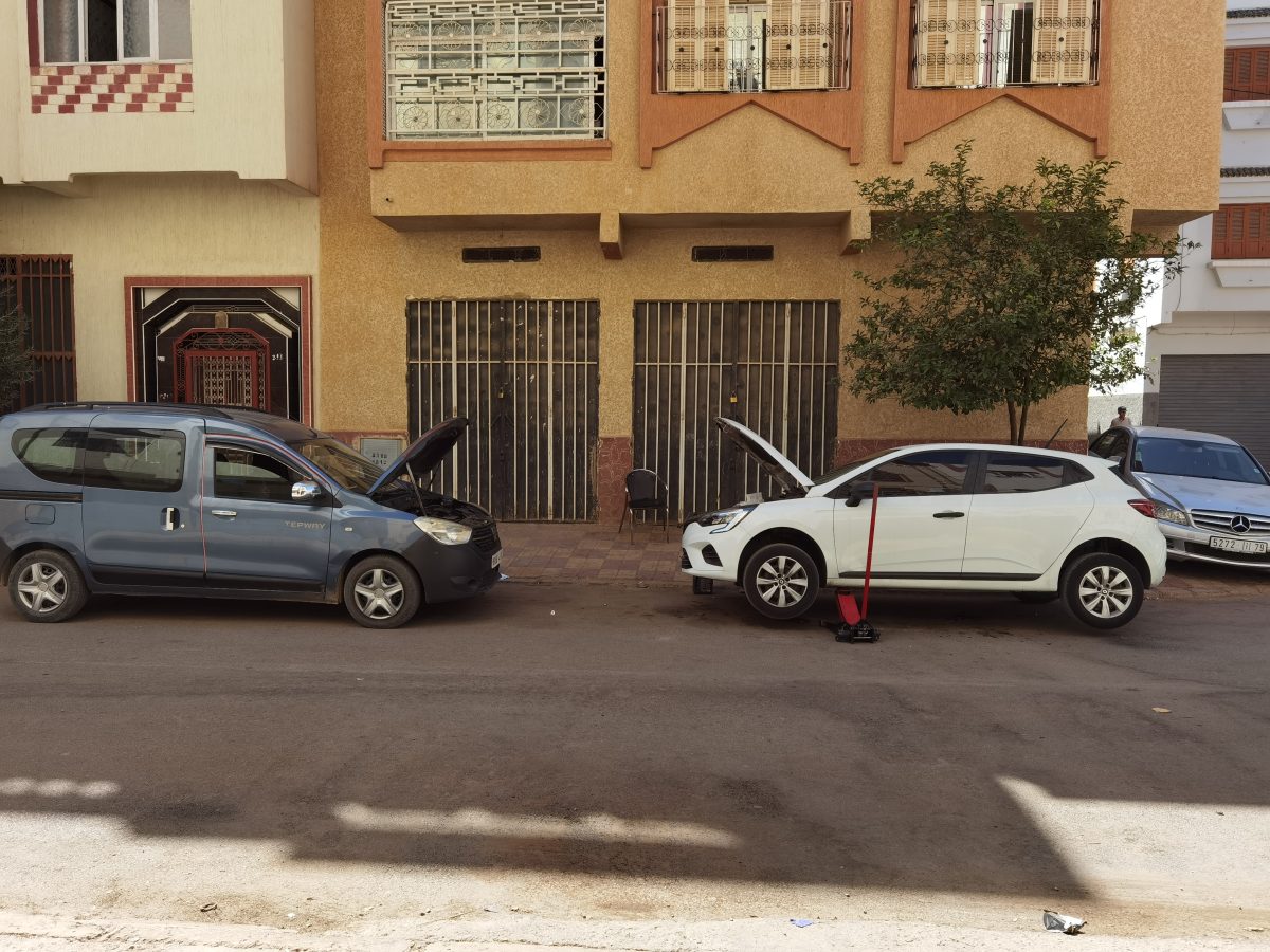 Deux voitures capot ouvert en dépannage dans une rue