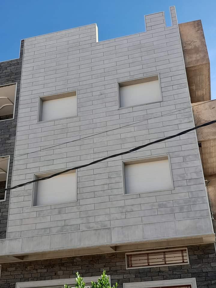 Façade d'immeuble en carrelage effet pierre gris
