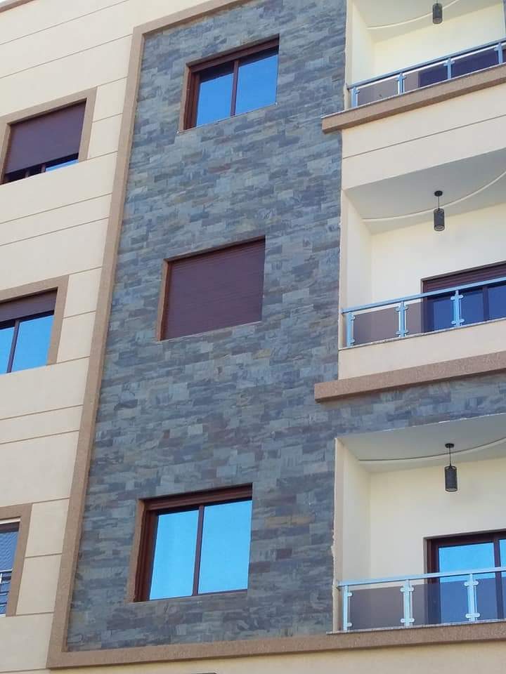 Façade d'immeuble à bandeau en parement de pierre