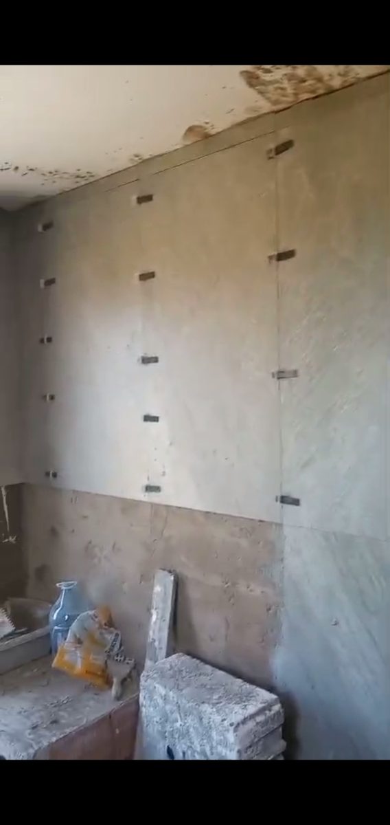 Mur préparé à taquets de nivellement pour carrelage