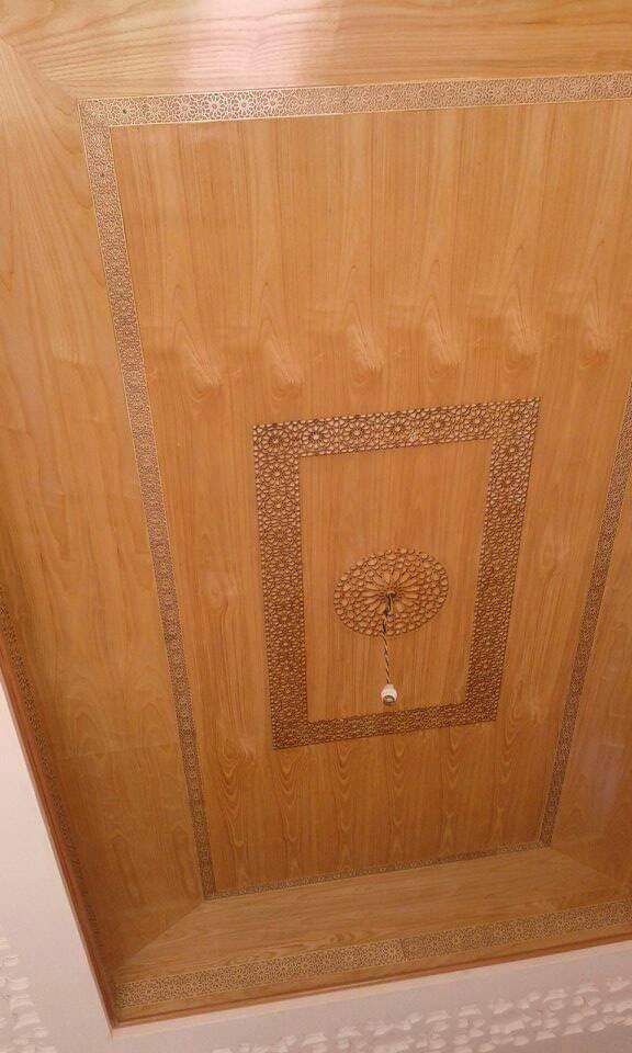 Plafond en lambris à frises dorées et rosace