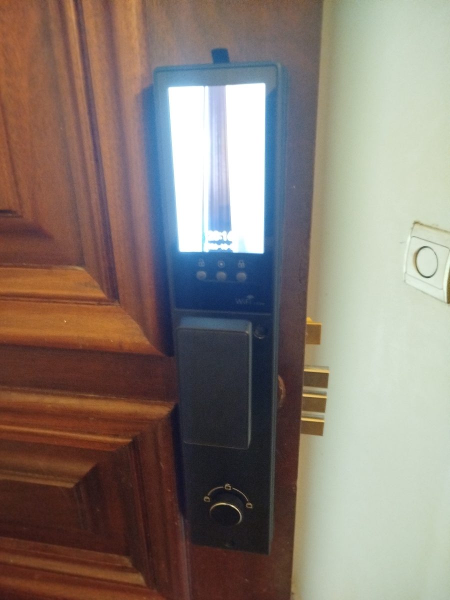 Serrure connectée verticale à écran sur une porte