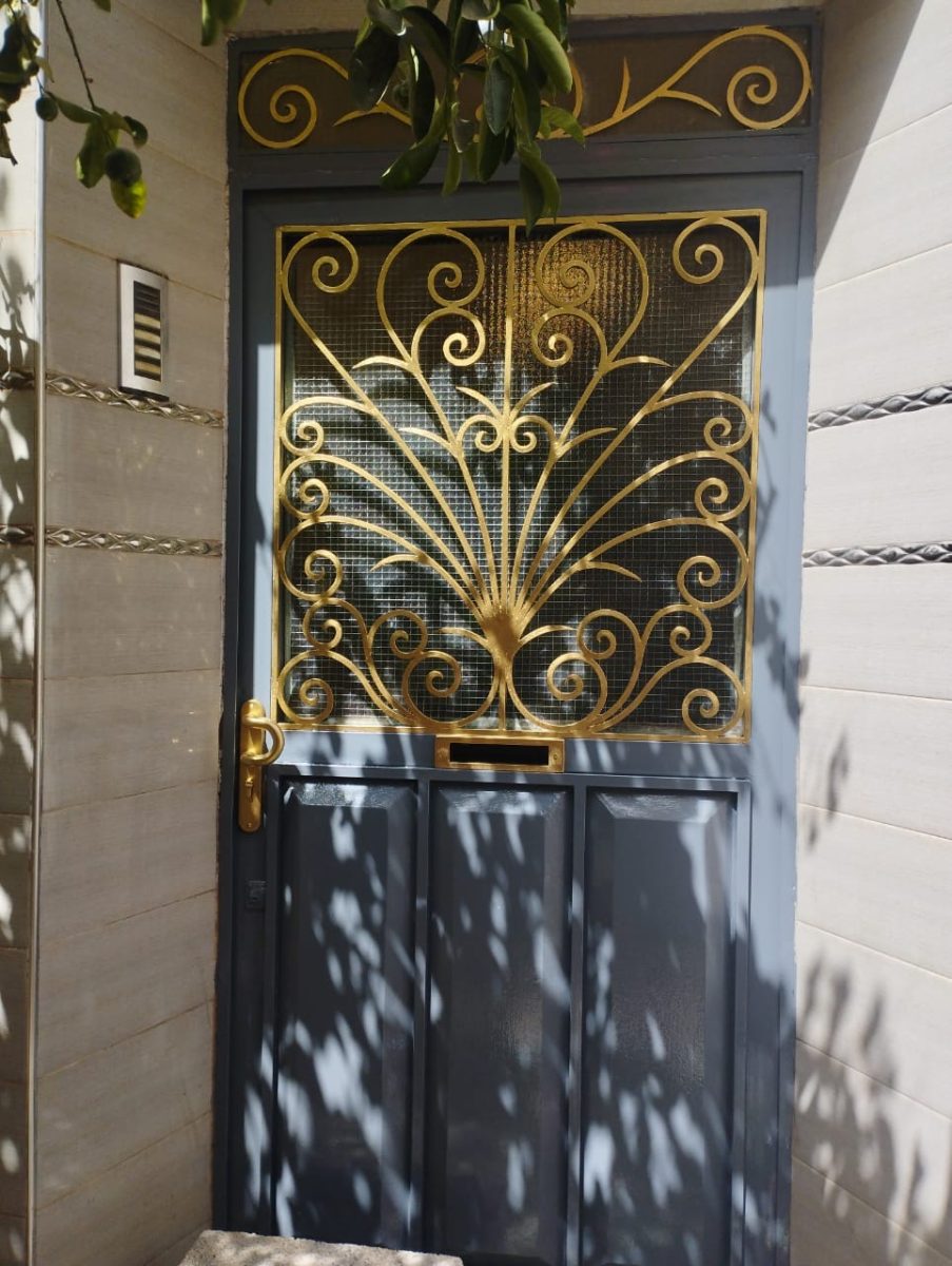 Porte d'entrée en fer à imposte en ferronnerie dorée