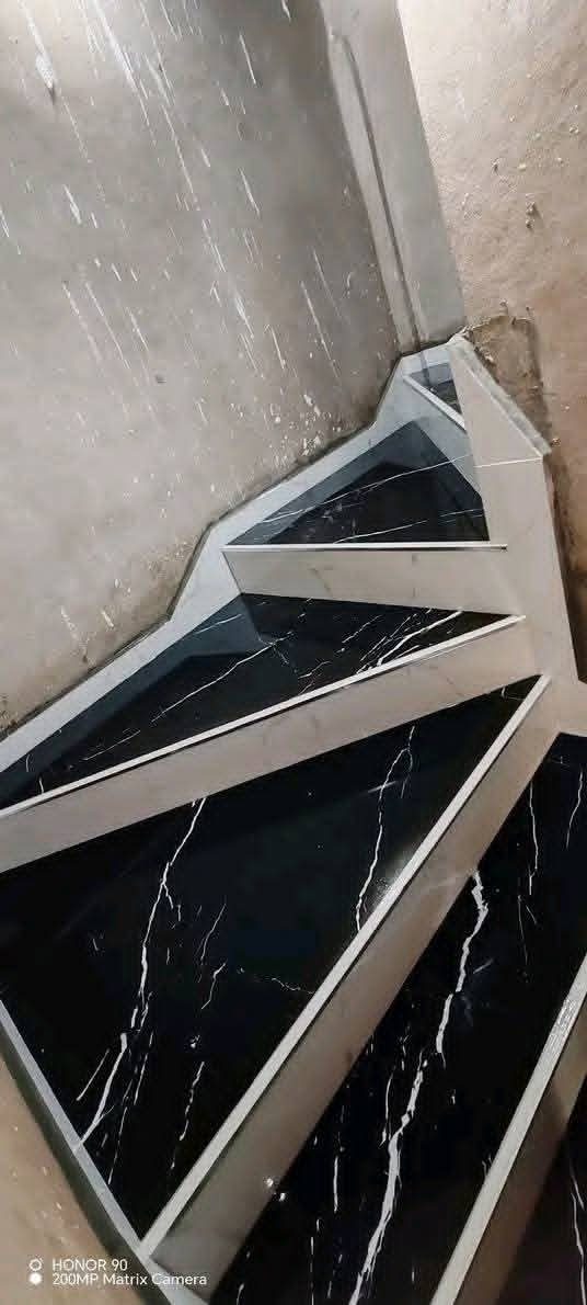 Escalier tournant en marbre noir veiné à nez inox