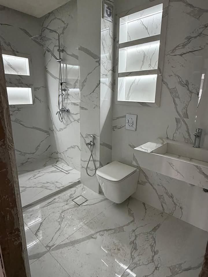 Salle de bain en marbre blanc à douche italienne