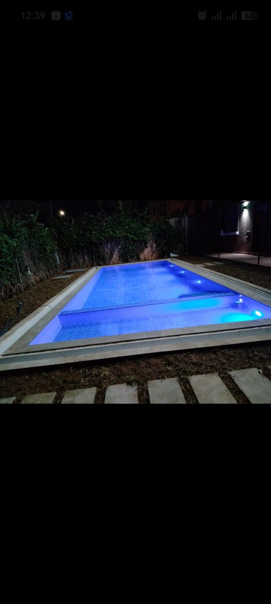 Piscine rectangulaire éclairée en bleu la nuit