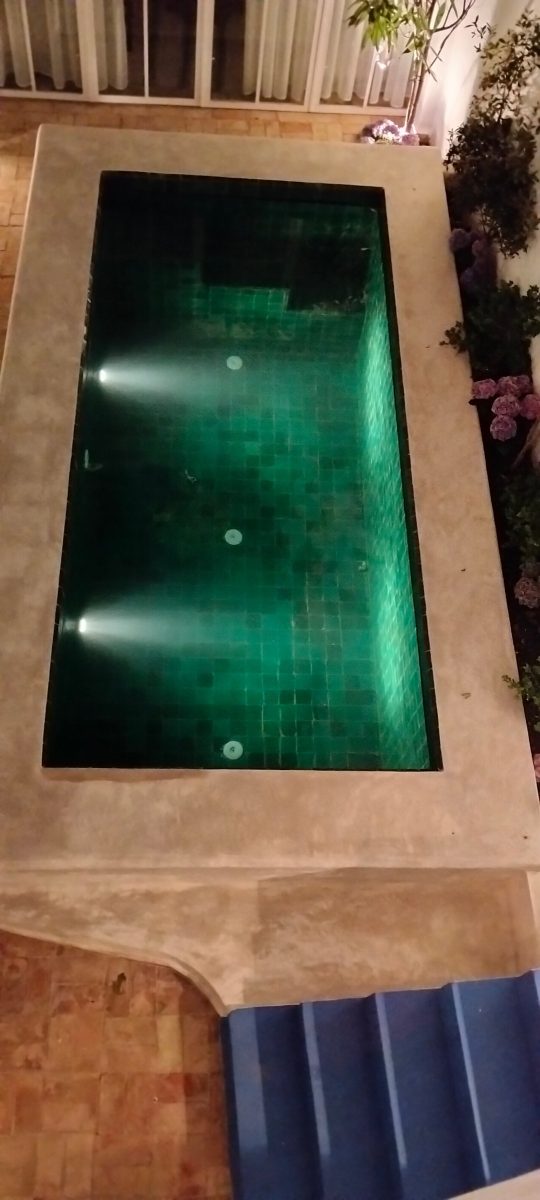 Piscine à revêtement en zellige vert éclairée
