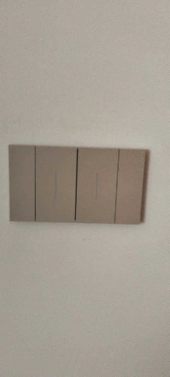 Interrupteur quadruple taupe sur mur blanc