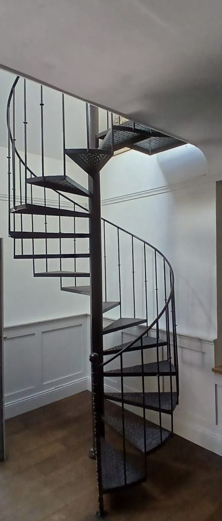 Escalier hélicoïdal en métal noir à caillebotis