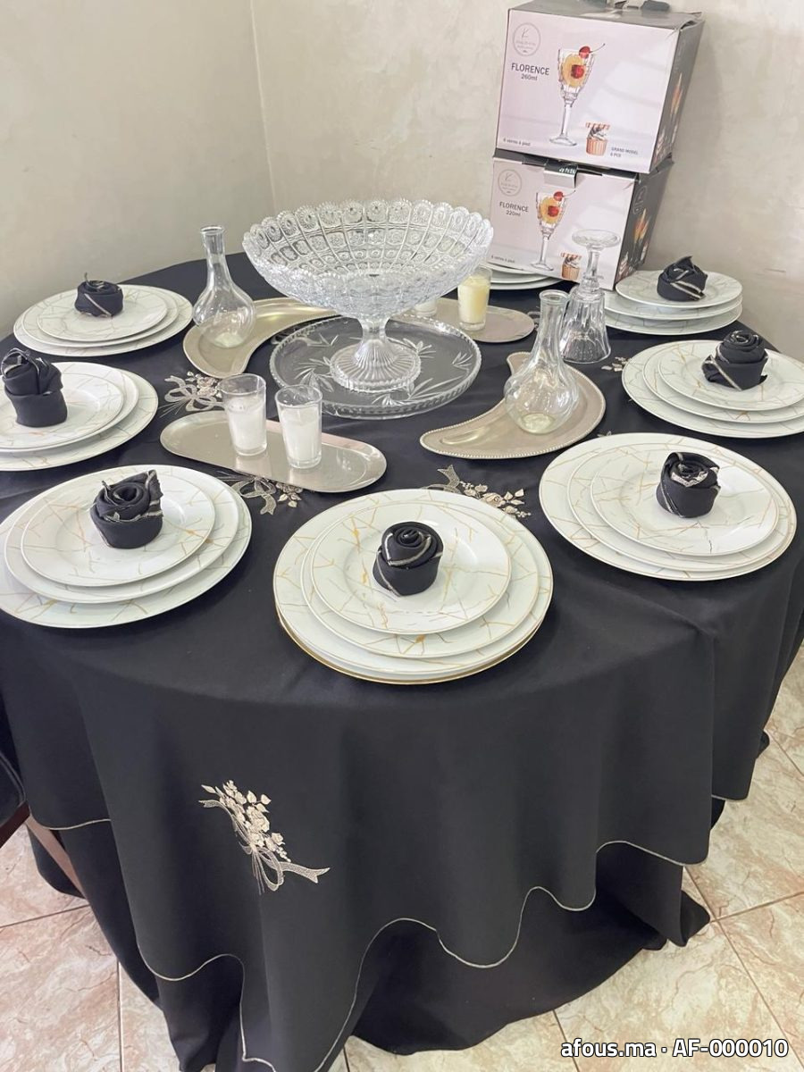 Table ronde en nappe noire avec vaisselle marbrée et serviettes en rose noire — Rabat